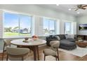 Bright open living room with large windows, plantation shutters, modern furnishings, and views of the water at 3943 Nw 219Th Street Rd, Micanopy, FL 32667