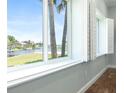 Bright room with view of the water and palm trees from the window with white shutters and wood floors at 3943 Nw 219Th Street Rd, Micanopy, FL 32667