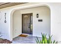 Inviting front porch featuring stylish tile flooring, a modern light fixture, and a mailbox at 716 Golfview St, Orlando, FL 32804