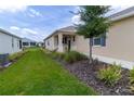 Well-manicured front yard with lush landscaping, healthy green grass, and stucco home with covered porch at 8925 Sw 76Th St, Ocala, FL 34481