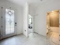 Bright foyer featuring marble floors, a decorative front door, and easy access to the bathroom and bedroom at 6612 Tempo Way, Mascotte, FL 34753