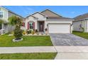 Inviting single-story home showcasing a well-kept lawn, beautiful landscaping, and an eye-catching red front door at 6612 Tempo Way, Mascotte, FL 34753