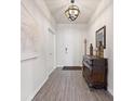 Bright entryway with wood-look floors, a decorative dresser, and stylish lighting at 9478 Sw 52Nd Loop, Ocala, FL 34481