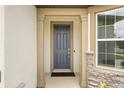 Covered entryway featuring a stylish front door with stone accents and decorative columns at 9478 Sw 52Nd Loop, Ocala, FL 34481