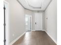 Inviting foyer with neutral paint, wood-look tile flooring, tray ceiling and access to other rooms at 3940 Se 5Th Ave, Ocala, FL 34480