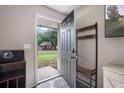 Welcoming foyer with coat rack, offering a glimpse of the beautifully landscaped front yard at 24 Sapphire Way, Ocala, FL 34472