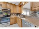 Charming kitchen featuring stainless steel appliances, tile backsplash, and granite countertops at 916 Ashmeade Ct, Port Orange, FL 32127