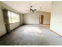 Spacious living room featuring vaulted ceilings, a ceiling fan, and a large window at 11027 Sw 75Th Ave, Ocala, FL 34476