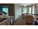 Functional kitchen and dining area with hardwood floors and modern stainless steel appliances at 32932 Crooked Oaks Ln, Leesburg, FL 34748