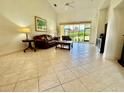 Spacious living room featuring tile floors, high ceilings, and a sliding glass door with abundant natural light at 3017 Mission Lakes Dr, Lakeland, FL 33803