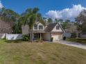 Charming two-story home featuring a manicured lawn, a palm tree, and a two-car garage at 1029 Evans Loop, Lake Wales, FL 33853