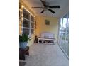 Enclosed porch with weathered bench, string lights, neutral decor, and a ceiling fan at 1120 S Scenic Hwy, Lake Wales, FL 33853