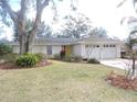 Single story home with mature landscaping and a two-car garage at 1163 Cephia St, Lake Wales, FL 33853