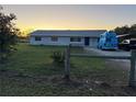 Ranch style house with a large yard at sunset at 2000 Mcclellan Rd, Frostproof, FL 33843