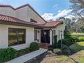 Inviting home exterior with red tile roof, neatly landscaped yard, and a charming black front door at 2680 Clubhouse Dr, Lake Wales, FL 33898