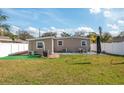 A view of the home's backyard featuring lawn space, patio, outdoor dining set, and privacy fence at 1831 Richmond Rd, Lakeland, FL 33803