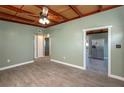 Living room features wood look flooring, ceiling fan, and openings to kitchen and bedroom areas at 1831 Richmond Rd, Lakeland, FL 33803