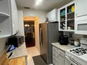 Efficient kitchen with stainless steel refrigerator and white cabinets at 200 El Camino Dr # 102, Winter Haven, FL 33884