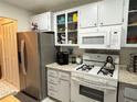 Galley kitchen with stainless steel refrigerator and white cabinets at 200 El Camino Dr # 102, Winter Haven, FL 33884