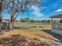 Large backyard featuring a grassy area, fence line and a fire pit feature at 2391 Buck Board Trl, Lake Wales, FL 33898