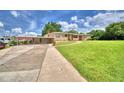 Inviting single-story home featuring a carport, an attached garage, and a lush green lawn at 301 S Clinch Lake Blvd, Frostproof, FL 33843