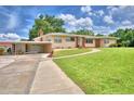 Lovely single-story home featuring a carport, attached garage, and a well-manicured green lawn at 301 S Clinch Lake Blvd, Frostproof, FL 33843