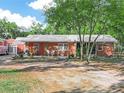A quaint single-story brick home with metal roof and comfortable front porch sitting area at 3123 Mar Lisa Cove Rd, Lake Wales, FL 33898
