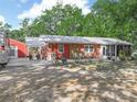 A single-story brick home with a metal roof, front porch sitting area, and an adjacent two-car garage at 3123 Mar Lisa Cove Rd, Lake Wales, FL 33898