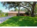 Well-maintained single-story home with green lawn and mature trees at 3567 Red Oak Ct, Lake Wales, FL 33898