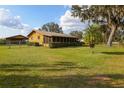 Spacious yard with a ranch-style home featuring a screened porch, mature trees, and a well-maintained lawn at 450 Westfall Dr, Kenansville, FL 34739