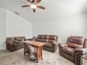 Well-lit living room featuring cozy seating, a ceiling fan, and stylish decor at 4833 Drake Ave, Lakeland, FL 33811