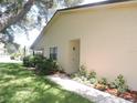 Exterior home view highlighting a walkway, landscaping, and a well-maintained lawn at 1077 Medinah Way, Winter Haven, FL 33884