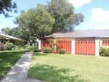 Attractive home exterior featuring a well-kept lawn, mature trees, and a neatly paved walkway at 1077 Medinah Way, Winter Haven, FL 33884