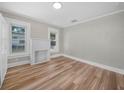 Comfortable bedroom featuring an eye-catching decorative fireplace and luxury vinyl plank flooring at 111 D St, Frostproof, FL 33843