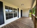Exterior front porch of house features wood flooring and a front door at 111 D St, Frostproof, FL 33843