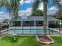 A refreshing in-ground pool featuring a safety fence for , perfect for summer fun, is surrounded by green grass at 1144 Cephia St, Lake Wales, FL 33853