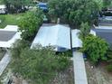 An aerial view of a single-Gathering home boasting a metal roof and a private boat dock on a serene canal at 1422 Avenue H Sw, Winter Haven, FL 33880