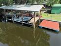 Exterior shot of boat dock with boat and outdoor seating, with direct access to deep water at 1422 Avenue H Sw, Winter Haven, FL 33880