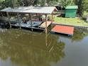 Picture of covered boat dock with boat and a floating dock along a waterfront canal at 1422 Avenue H Sw, Winter Haven, FL 33880