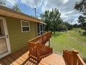 Elevated wooden deck and stairway lead to the house, showcasing the natural surroundings at 1885 Pfundstein Rd, Babson Park, FL 33827