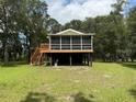 Scenic elevated home with a screened porch, nestled in a serene, tree-filled environment at 1885 Pfundstein Rd, Babson Park, FL 33827
