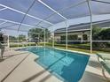 Relaxing screened-in pool area with lounge chairs, perfect for enjoying sunny days and outdoor entertaining at 2200 Mallory Cir, Haines City, FL 33844