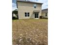 A partially grassed backyard with sliding glass door access to the home at 2655 Swooping Sparrow Dr, Harmony, FL 34773