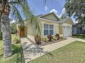 Inviting single-story home with a lush lawn, vibrant landscaping, and an attached one-car garage at 2692 Hemingway Ave, Haines City, FL 33844