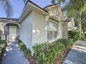 Well-manicured front of house featuring lush landscaping, a covered entrance, and freshly painted exterior at 2696 Hemingway Ave, Haines City, FL 33844