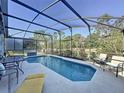 Inviting screened-in pool area with ample seating, perfect for relaxation and entertaining with a view at 2696 Hemingway Ave, Haines City, FL 33844