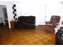 Spacious living room featuring neutral walls and parquet wood flooring at 302 S Palm Ave, Frostproof, FL 33843