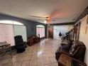 Bright living room featuring tile floors, ceiling fan, and natural light at 400 W 4Th Ct, Frostproof, FL 33843
