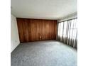 Cozy living room features wood paneling, neutral carpet, and ample natural light at 405 S Shore Dr, Eagle Lake, FL 33839