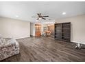 Spacious living room with wood floors leading to a dining area, featuring a ceiling fan and comfortable seating at 509 Mountain Dr, Babson Park, FL 33827